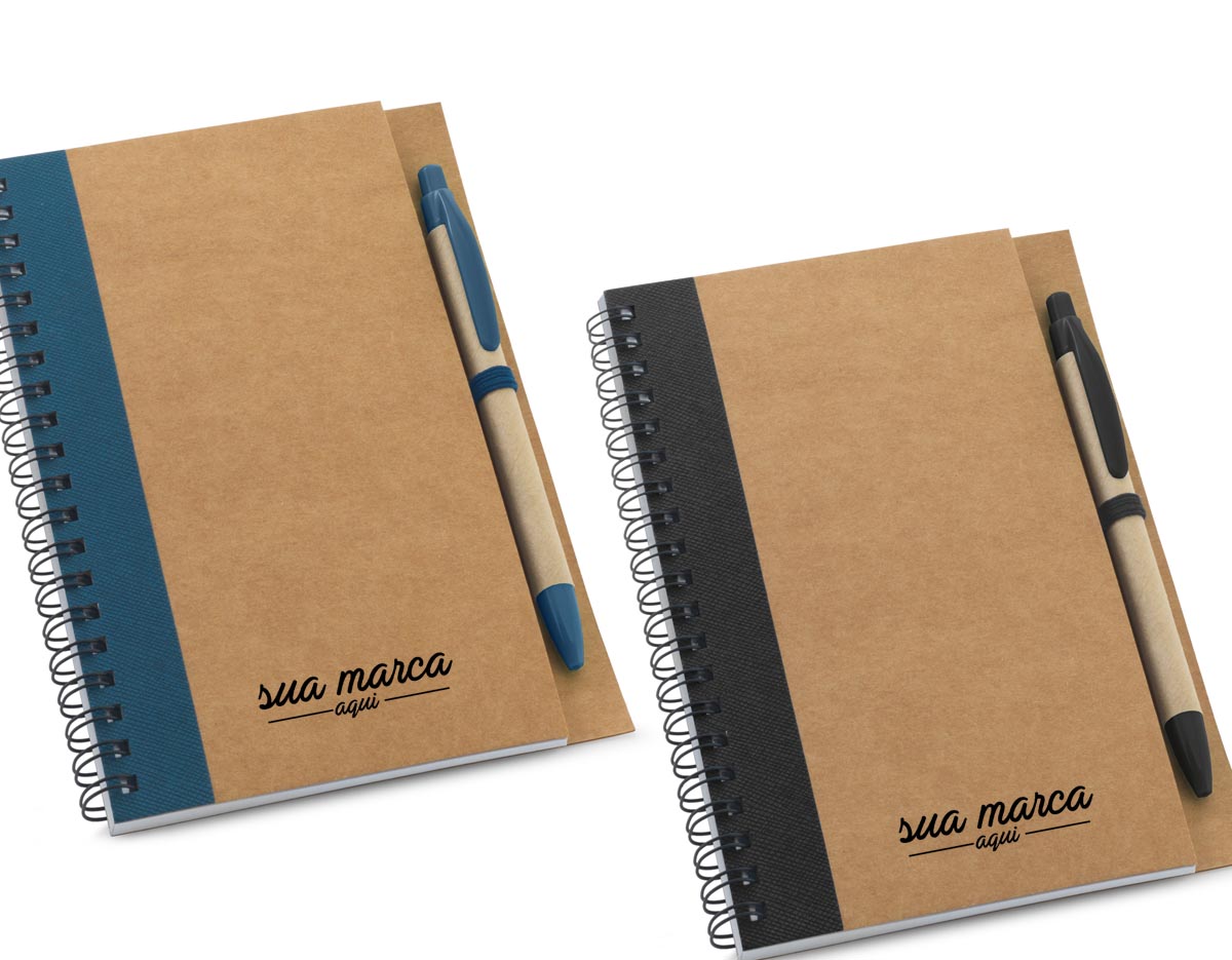 Caderno B6 espiral de capa dura em cartão, com 120 páginas lisas em papel reciclado e suporte para esferográfica (inclusa). 