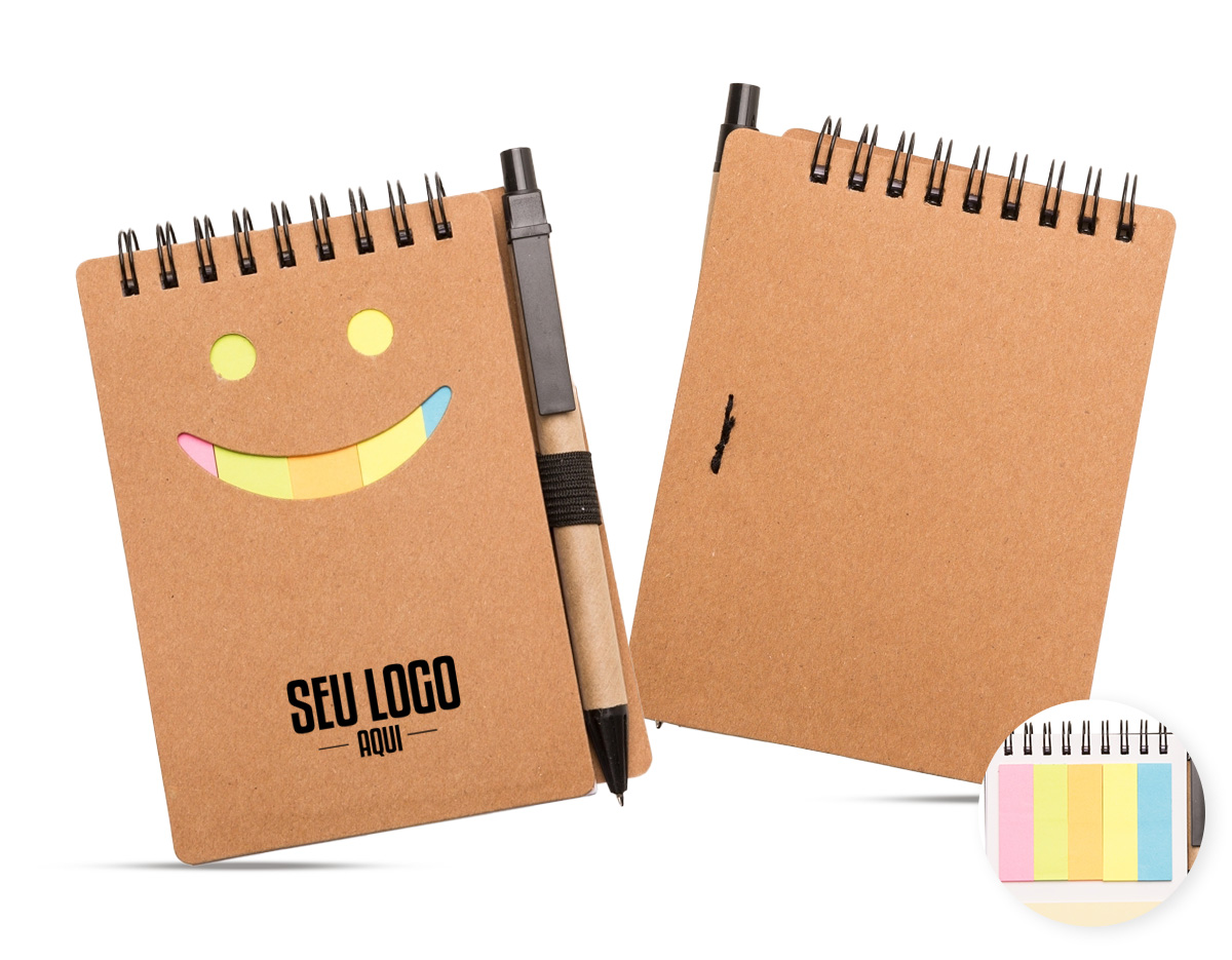 Bloco de anotações ecológico com caneta de papelão. Possui detalhe "smile" na capa frontal(verso liso), caneta ecológica com acabamentos em plástico acionada por clique, primeira folha(branca) com cinco blocos autoadesivos coloridos com aproximadamente 20 folhas cada, bloco amarelo com aproximadamente 20 folhas e 70 folhas brancas pautadas.