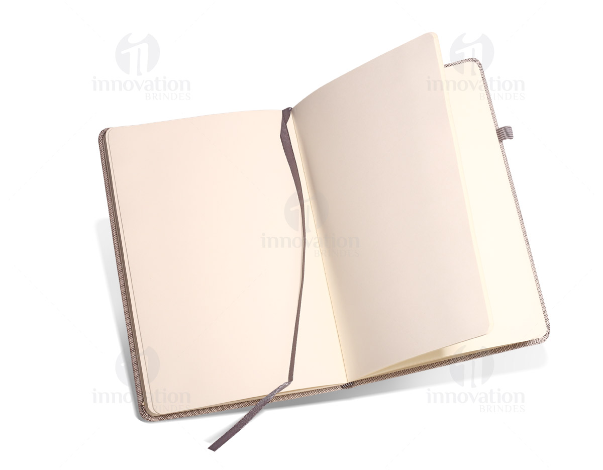 Caderno capa dura com porta esferográfica e folhas não pautadas cor marfim. Fornecido em embalagem de non-woven. Esferográfica não inclusa.