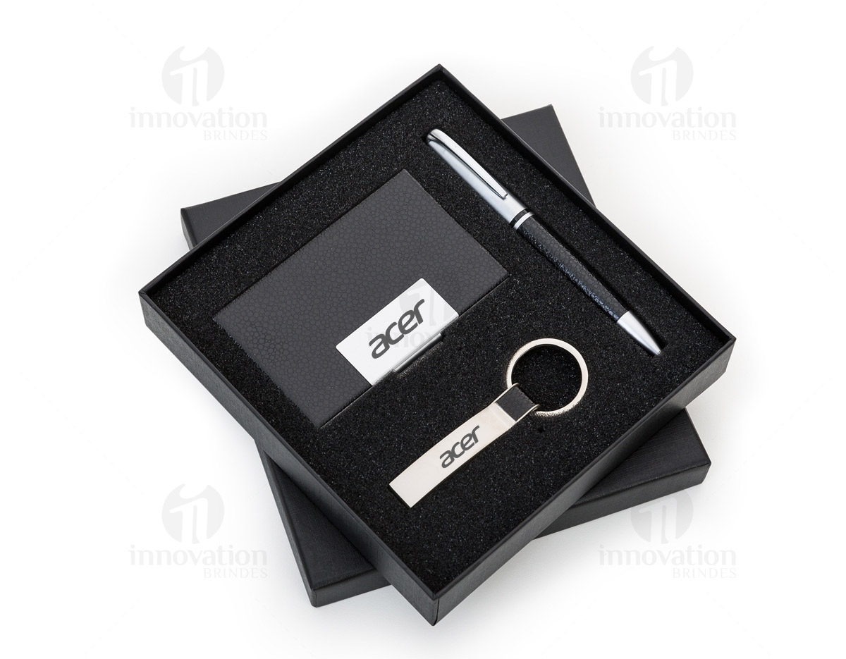 Kit executivo 3 peças em estojo de papelão com tampa e parte interna revestida de espuma. Contém: chaveiro metal fosco com detalhe em couro preto, porta cartão de couro sintético(verso metálico liso) com placa de metal e caneta metal fosca com detalhe emborrachado preto.