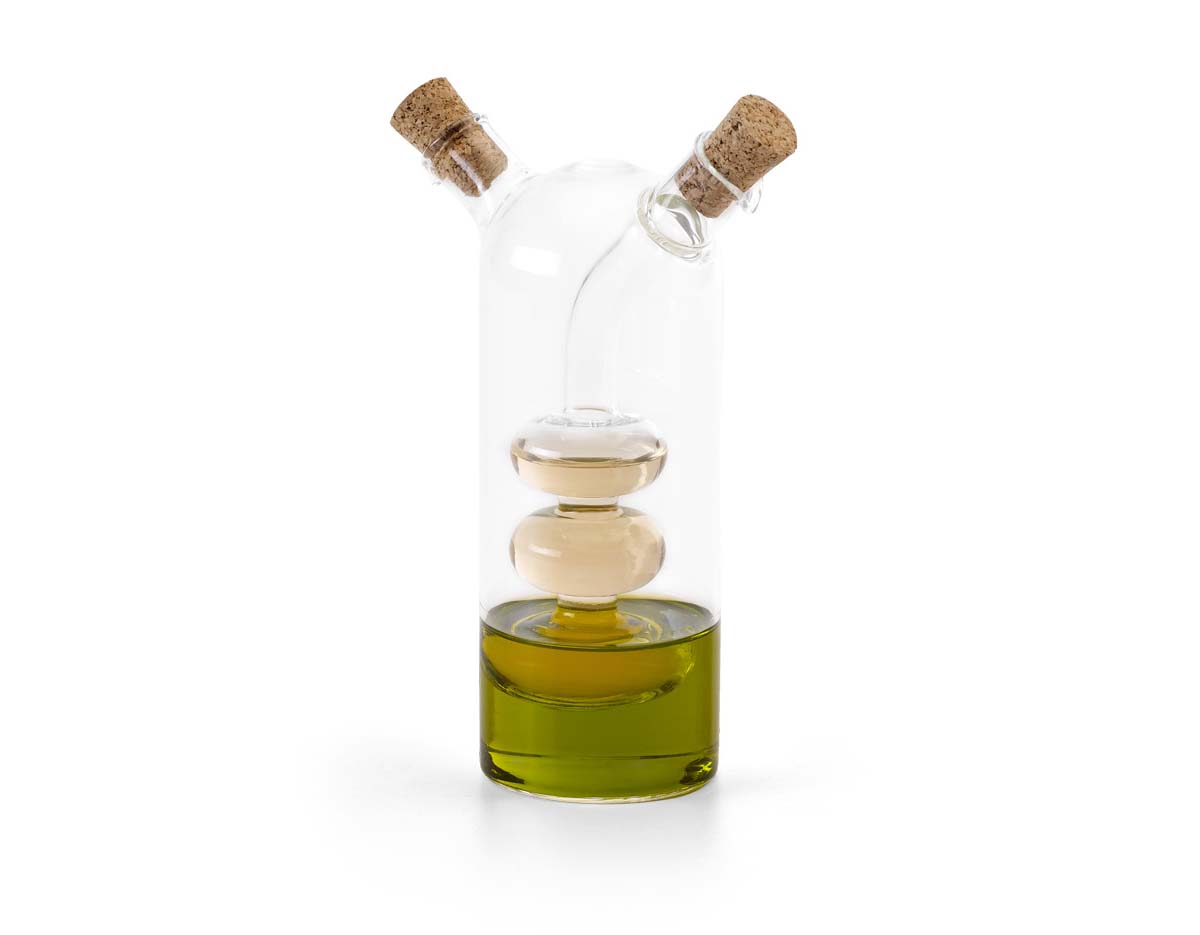 Galheteiro em vidro que contém dois reservatórios com capacidades de até 50 ml e de até 250 ml. O galheteiro contém duas rolhas de cortiça.