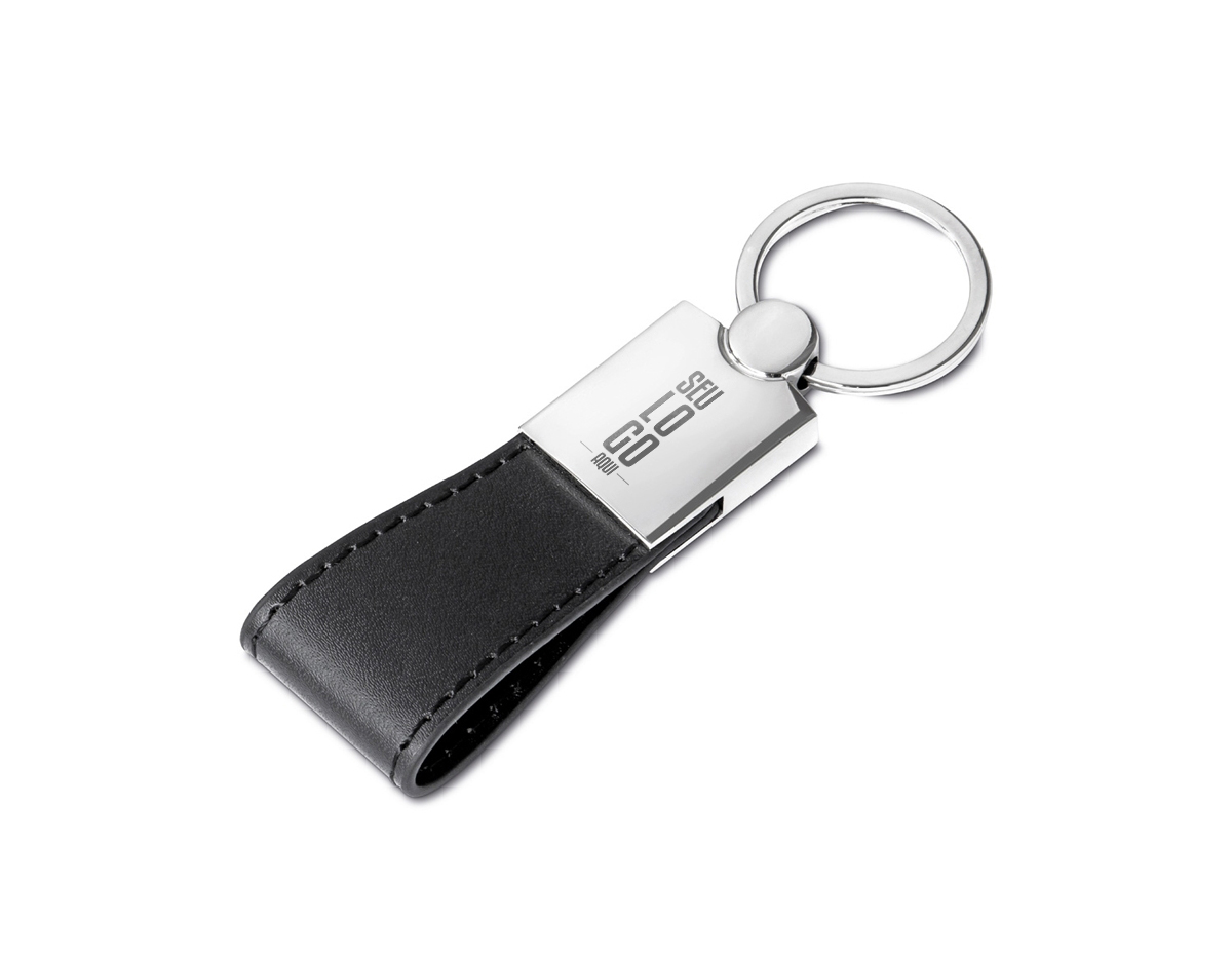 Chaveiro elegante em metal brilhante, com alça de couro sintético e design minimalista. Frente lisa e verso com dois parafusos para possível personalização. Ideal para adicionar um toque de sofisticação às suas chaves.