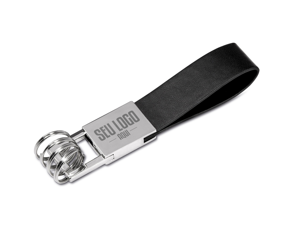Chaveiro de metal com 4 argolas e alça em couro sintético, possui “mosquete” giratório (para utilização basta levantá-lo e rotacionar). Metal brilhante com frente lisa e verso com um parafuso inferior.