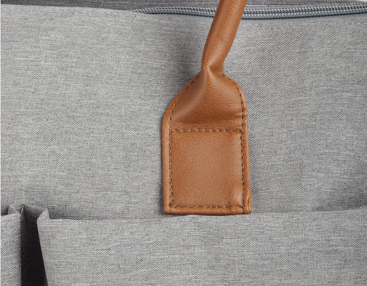 Mochila funcional em poliéster e couro sintético, equipada com compartimento principal com divisórias para organização. Possui alças de ombro e de mão, além de quatro bolsos laterais para armazenamento adicional. Ideal para uso diário e versátil.
