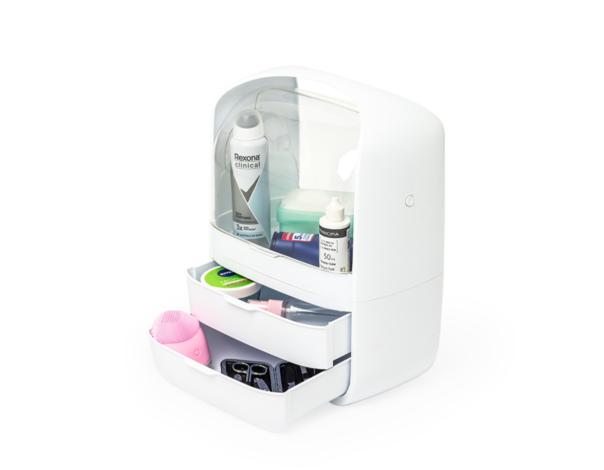 A caixa organizadora para maquiagens e cosméticos é prática e eficiente. Feita em plástico resistente com tampas de acrílico, ela protege os itens contra poeira e umidade, garantindo que tudo fique sempre seguro e preservado. Com um compartimento principal espaçoso e duas gavetas extras, é possível armazenar tudo de forma organizada. Além disso, a alça de transporte facilita levar a caixa para qualquer lugar, transformando qualquer ambiente no espaço perfeito para a rotina de beleza.