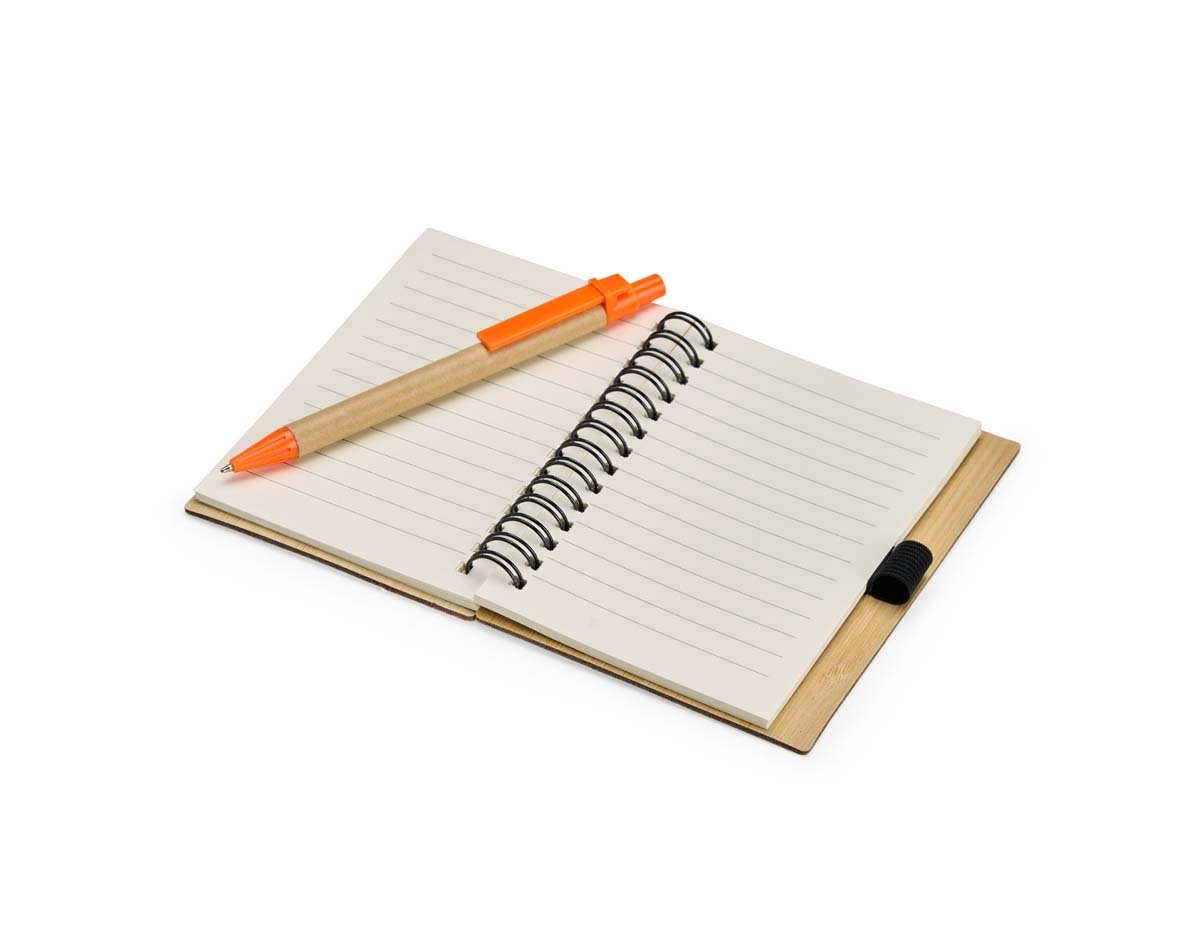 Caderno com capa de casca de bambu e faixa colorida, encadernação Wire-O e cerca de 70 folhas pautadas amareladas. Acompanha caneta esferográfica azul (0,8 mm), com corpo de papelão, clip, ponteira plástica e acionamento por clique. Elástico na capa para fixar a caneta.