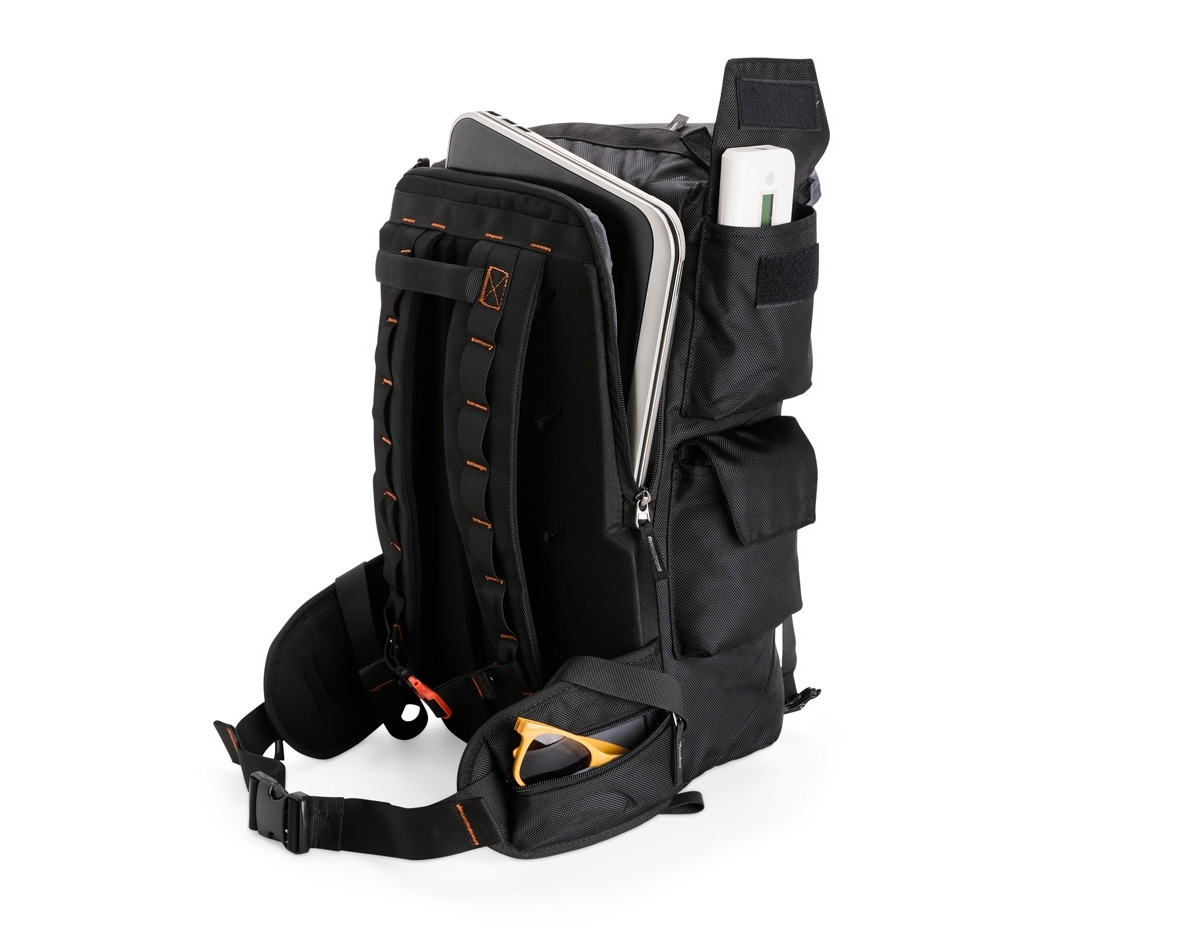 Mochila confeccionada em poliéster impermeável, fechamento por cordão e engate rápido plástico e capacidade máxima de 24 litros. Possui amplo espaço interno com divisória com fechamento em velcro e bolso em tela de nylon próximo à abertura. Apresenta três compartimentos externos: um com fechamento em zíper e dois em velcro nas laterais, além de um bolso lateral em tela de nylon. A parte traseira da mochila conta com outros três compartimentos em diferentes tamanhos, incluindo espaço para notebooks de até 15,6 polegadas.